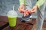 Women lacing her shoe and getting ready for fitness pratice with green smoothie.